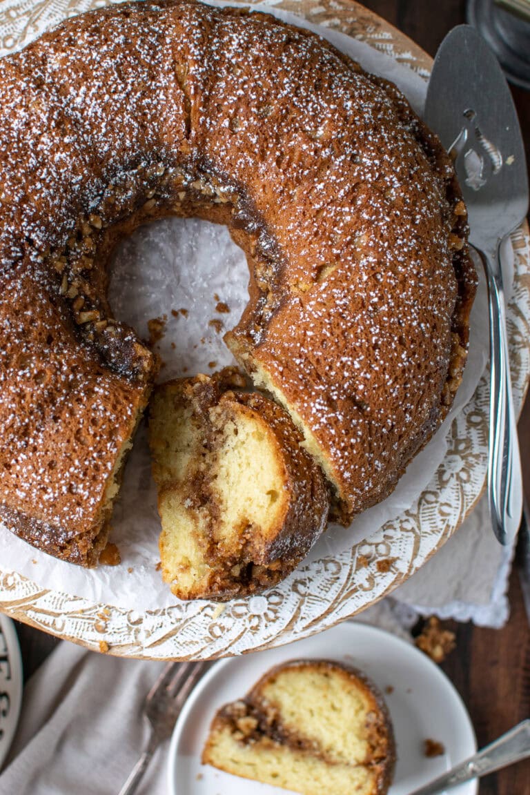 An overhead view of a cinnamon coffee cake with a slice cut out and laying on its' side.