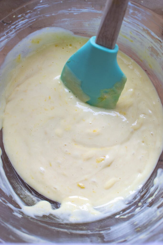 Filling for lemon squares in a glass mixing bowl.