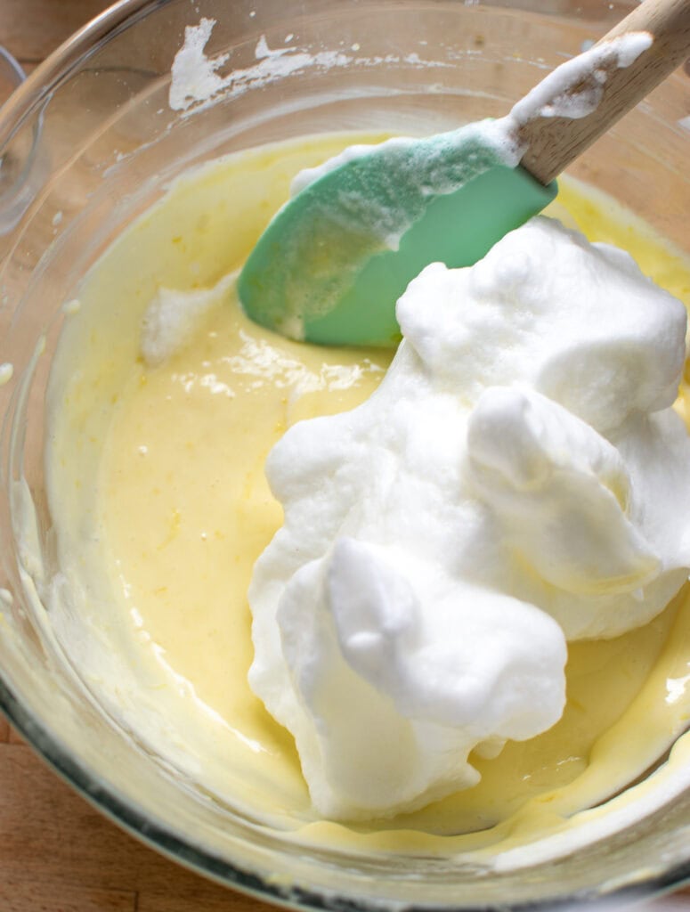 Beaten egg whites being folded into the lemon filling for lemon bars.