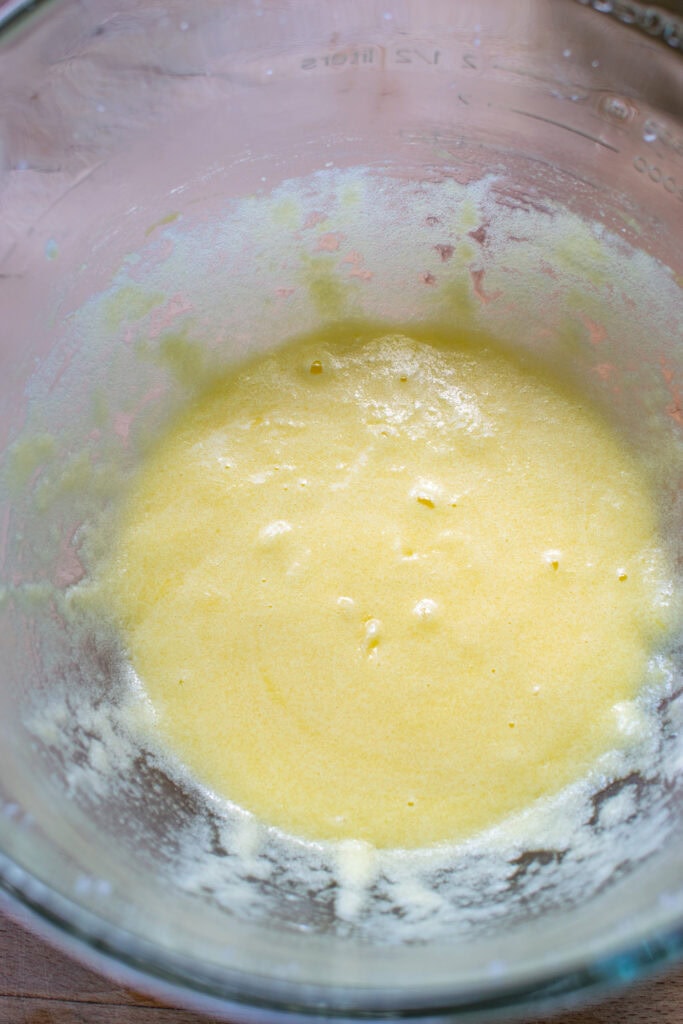 Eggs added to butter and sugar mixture for making banana bread.