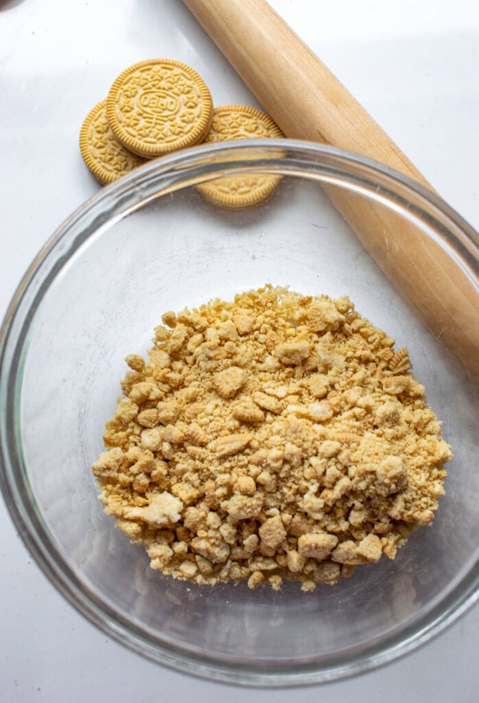 A glass bowl of crushed Golden Oreo cookie crumbs.