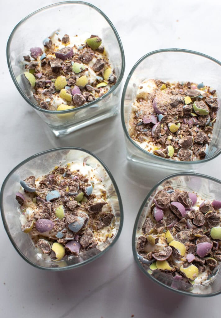 Crushed chocolate Easter mini eggs on top of the cream cheese layer of a chocolate parfait.