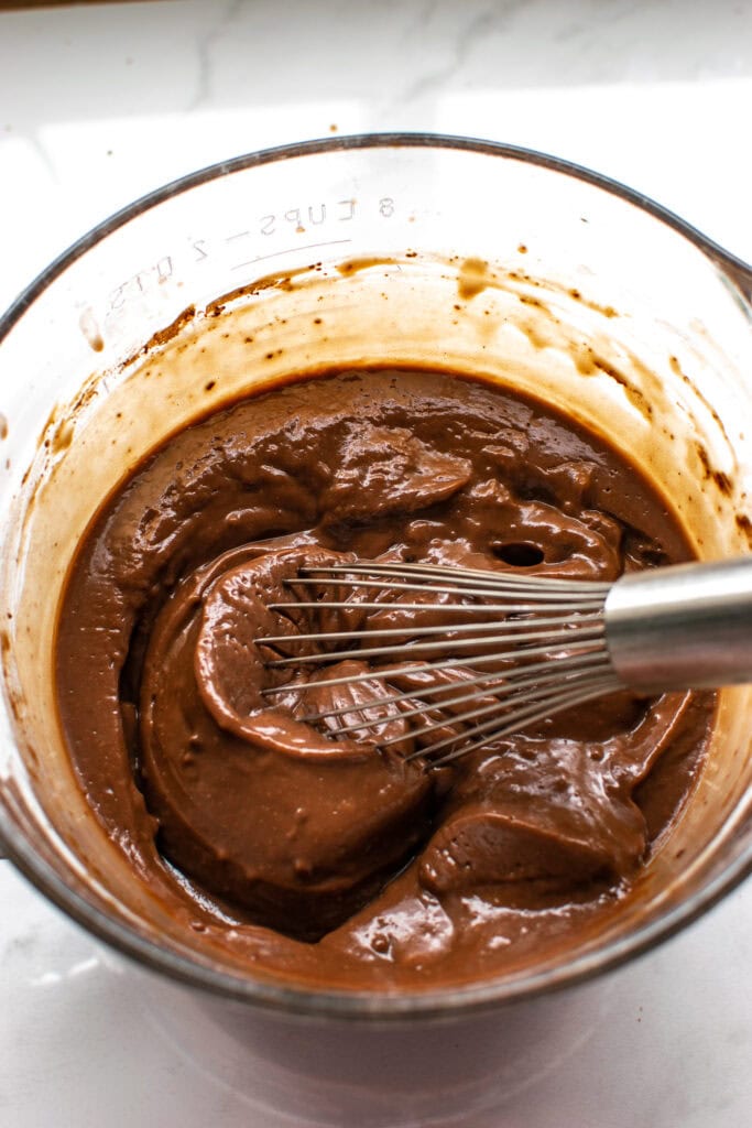 Chocolate pudding in a glass bowl that has just been whisked to thicken it.