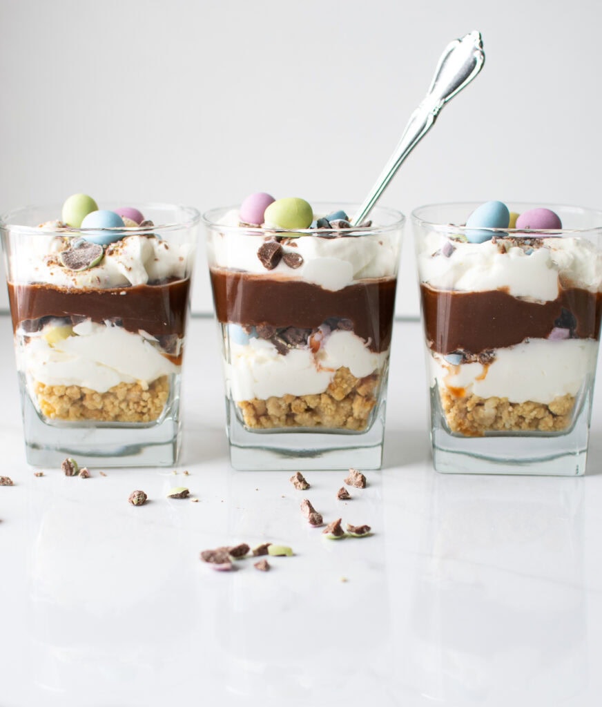 Three Easter chocolate parfaits, with the one in the middle having a spoon in it.