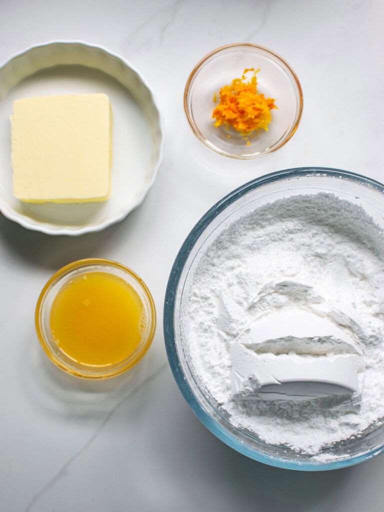 Ingredients to make orange buttercream frosting.