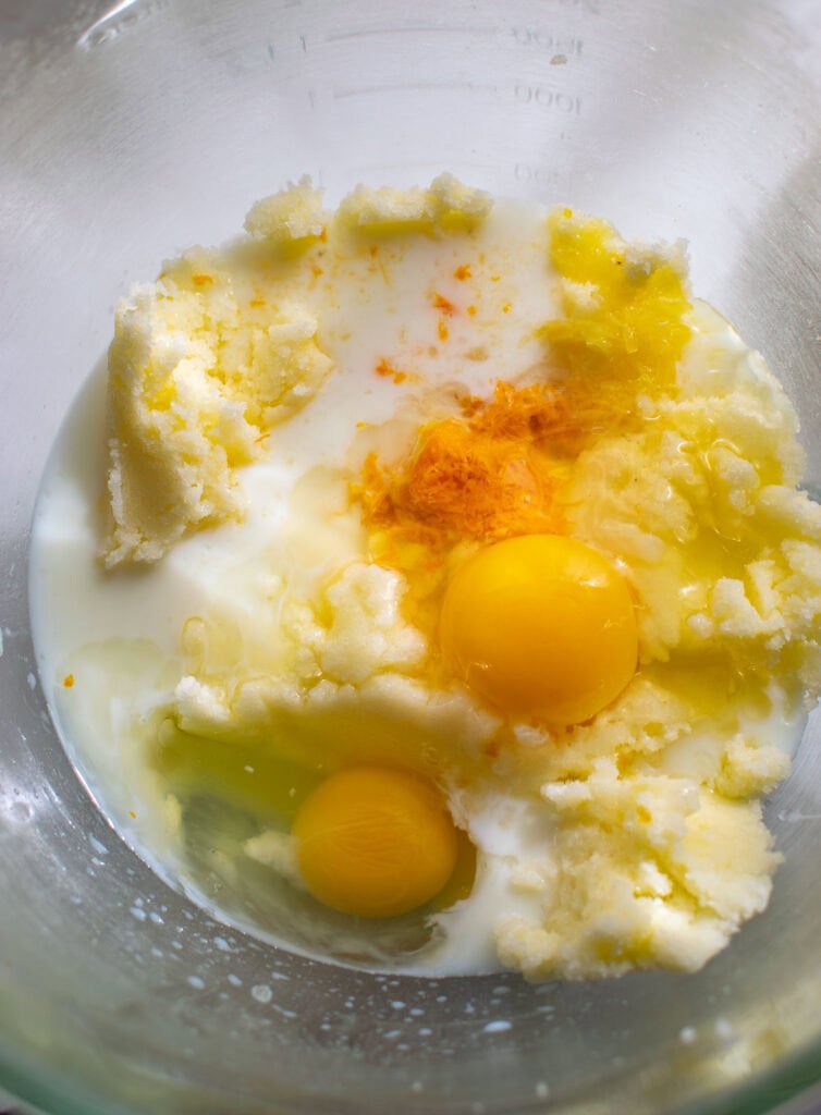 Eggs, milk, orange juice and orange rind added to creamed butter and sugar mixture.